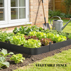 Black metal picket fence edging surrounding a vegetable bed in backyard.