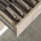 Close-up of natural wood drawer frame and metal handle detail on storage cabinet