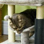 Grey cat tree perch with pom toy; dark grey scratching post beside the resting area.