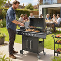 Black gas grill with open lid and food cooking on grates, storage doors visible