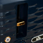Close-up of blue toaster lever and control dial with gold trim accents