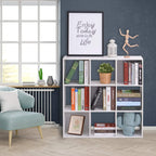 White storage shelf with open cube cubbies, styled with books and a small plant.