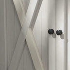 Light grey wooden storage shed door panel with black round knobs and cross-brace detail