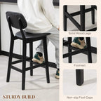 Black bar stool with faux-leather seat, solid wood legs, and lower footrest support