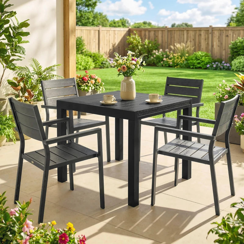 Black outdoor dining table set with slatted top and four chairs on patio