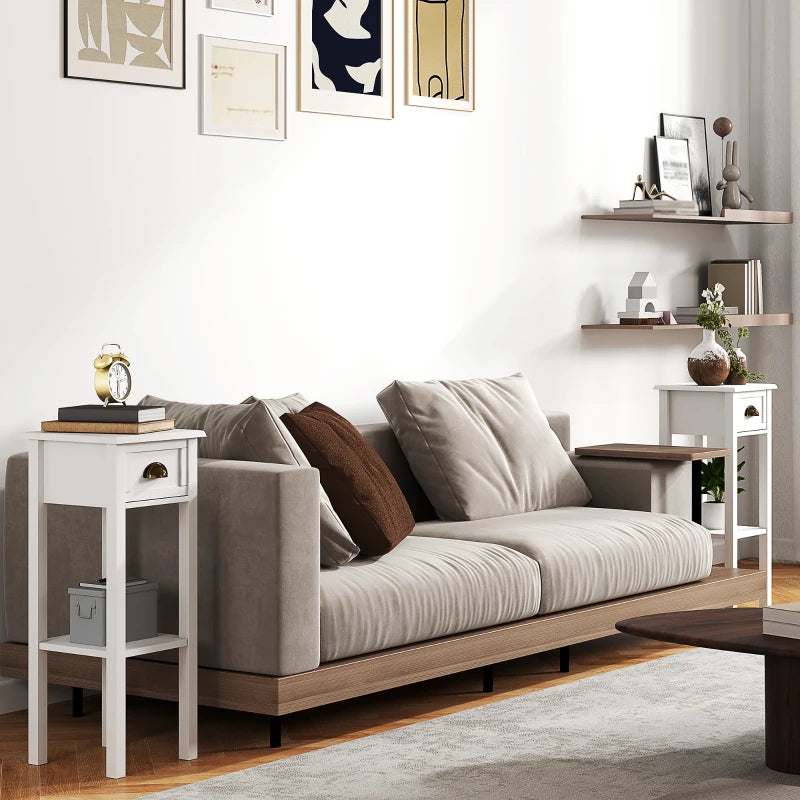White bedside table set with drawers and open shelves next to sofa