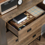 Brown chest of drawers with open drawer showing notebooks and black handles