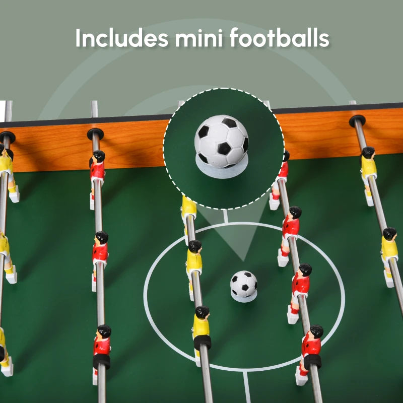 Foosball table with mini soccer balls on green pitch and player rod handles