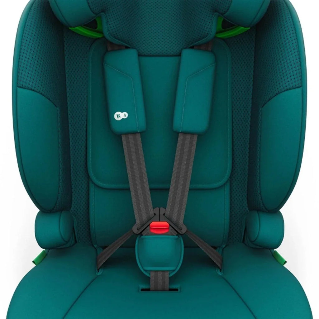 Green car seat close-up of front harness straps with red release button.