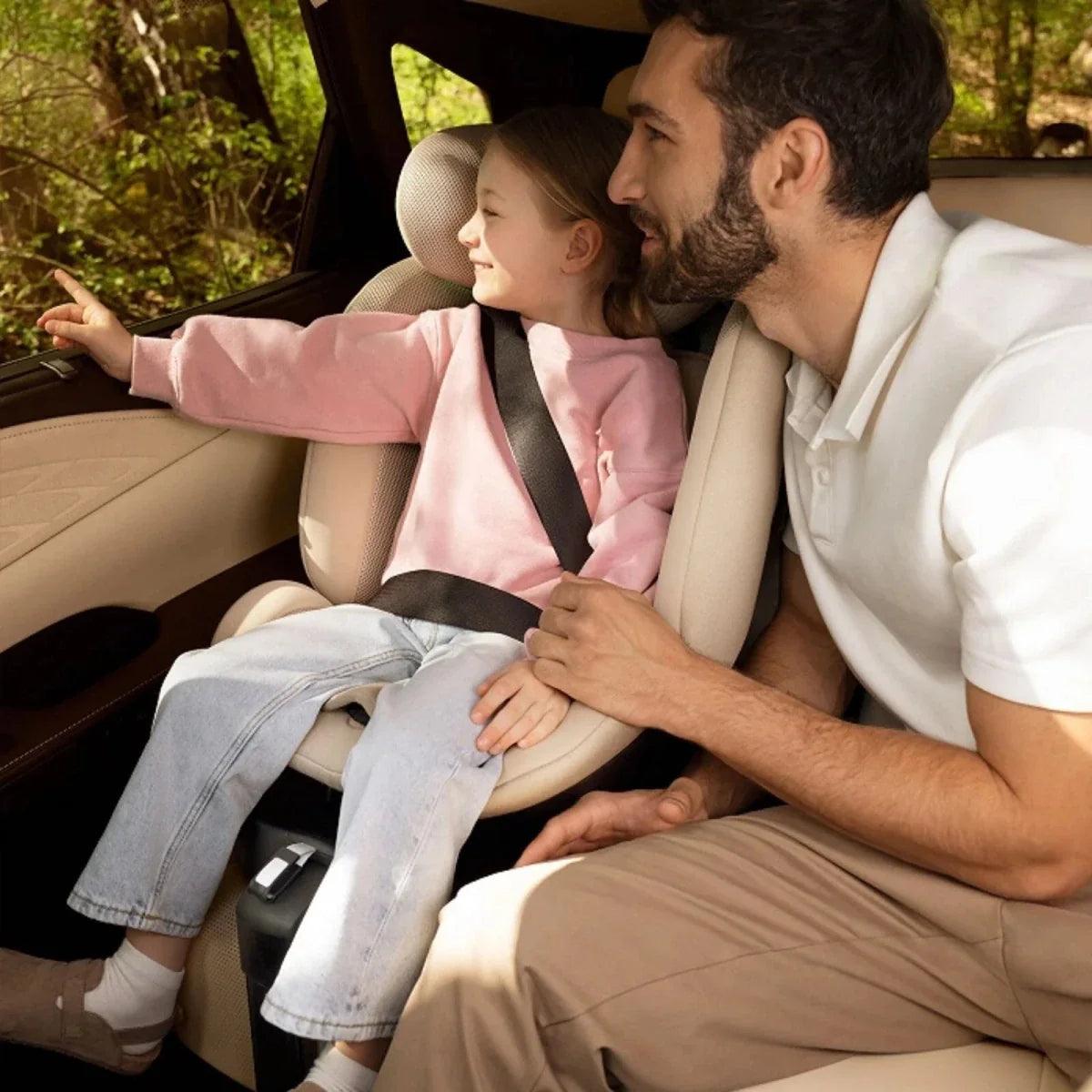 Grey modular infant car seat with headrest and harness, shown in vehicle.