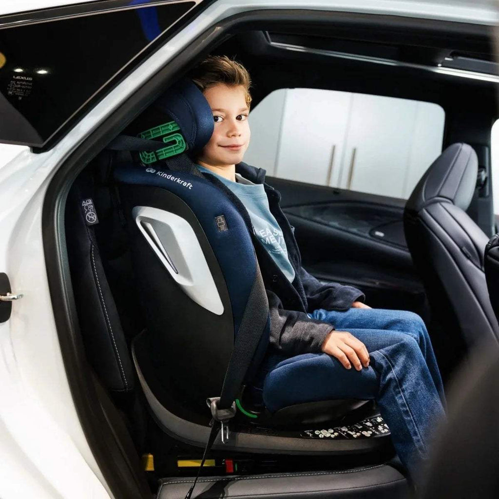 Blue car seat with padded headrest and harness on vehicle seat for child