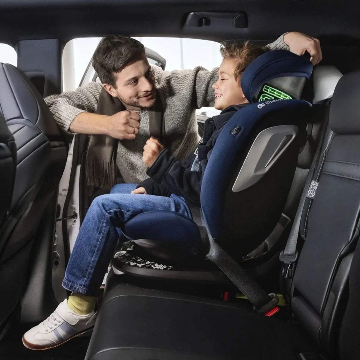 Blue and dark car seat in vehicle, headrest and side shield visible