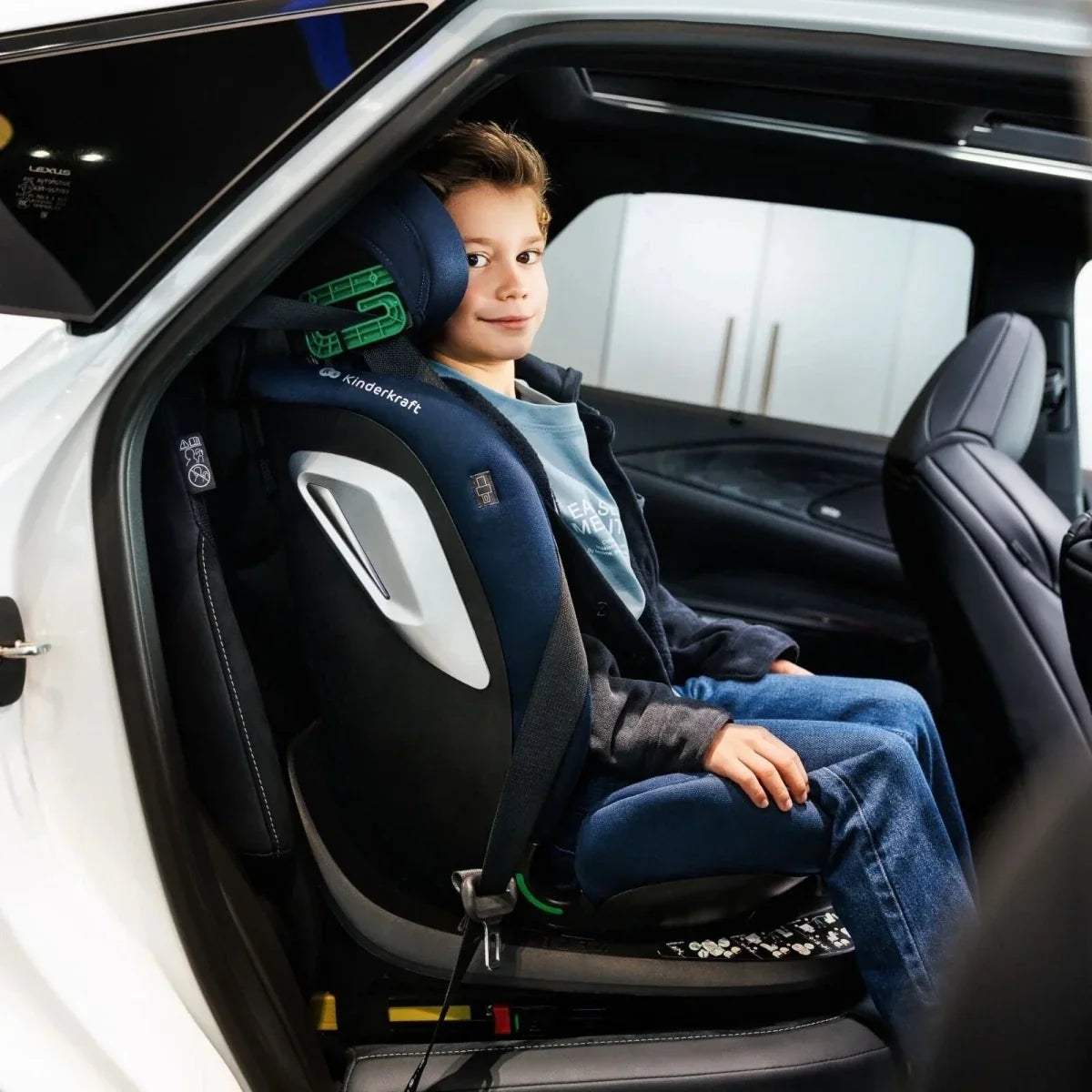 Blue and dark car seat with child seated, side profile in vehicle