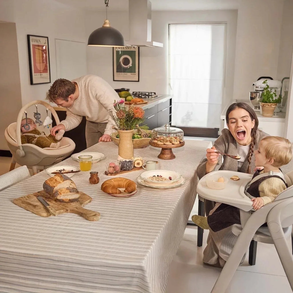 Beige 3-in-1 high chair in a dining scene with child seated at the table