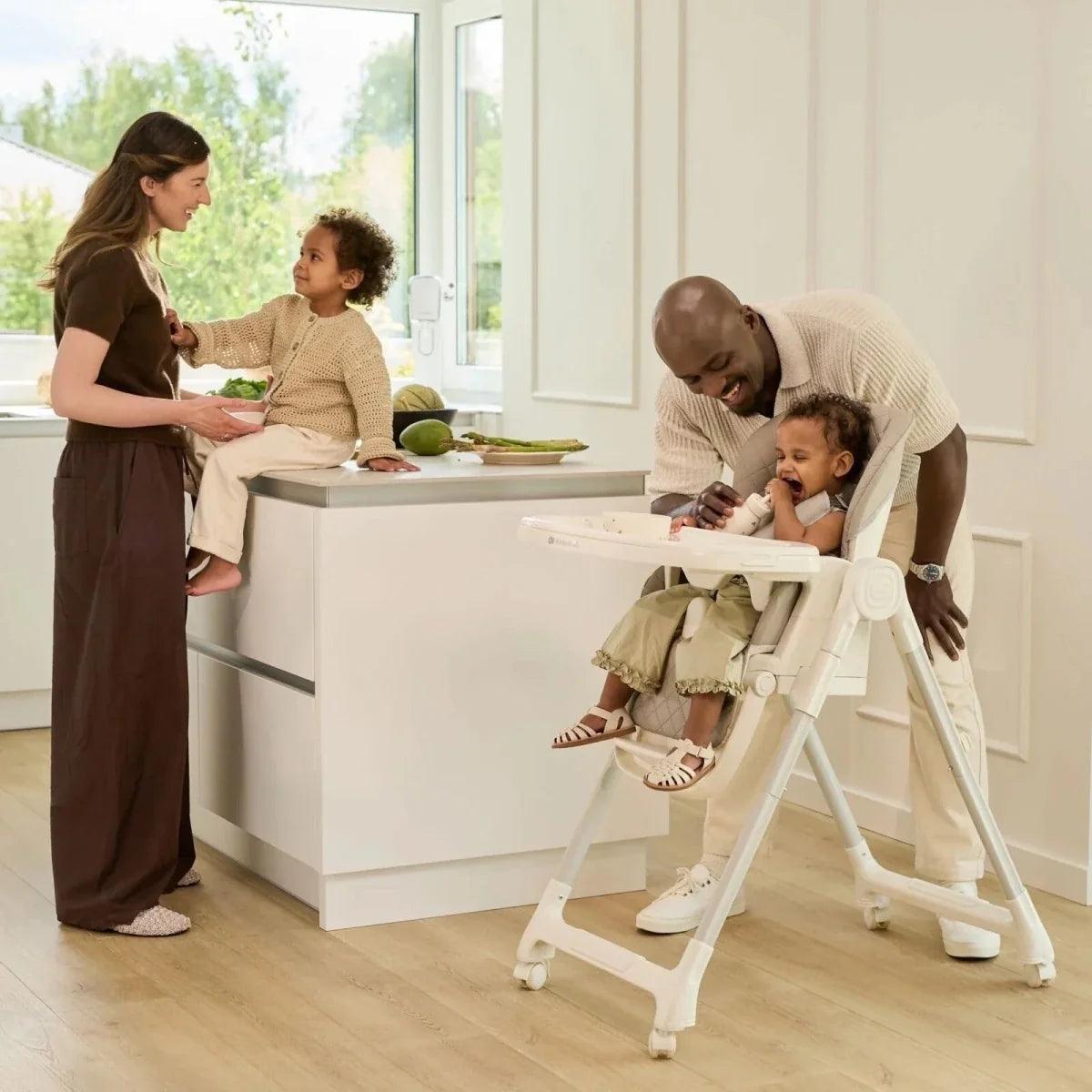 Beige high chair with extended tray and padded seat, harness and footrest visible