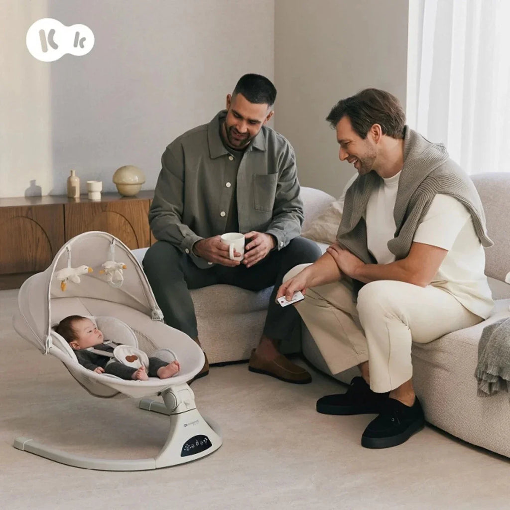 Grey baby swing seat with reclined infant holder and base, baby lying inside