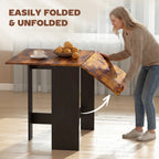 Rustic brown folding drop-leaf dining table with leaf being opened