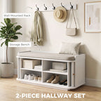 White hallway storage bench with removable cushion and wall-mounted coat hooks