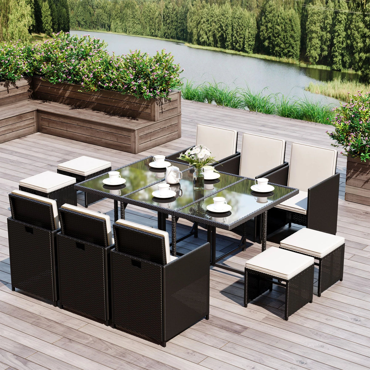 Black rattan dining set arranged around a glass table with white cushions and stools