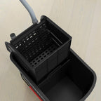 Black mop bucket close-up showing inner chamber and mesh wringer basket