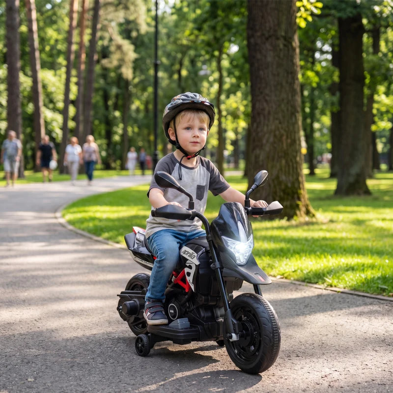 Black kids electric motorbike with front headlight, child riding outdoors