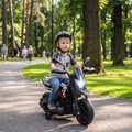 Black kids electric motorbike with front headlight, child riding outdoors