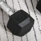 Black hex rubber dumbbell head with 5kg mark and textured finish
