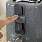 Grey toaster with crumb lever and browning control dial, hand pressing
