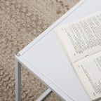 White square steel table corner with smooth tabletop and open frame base