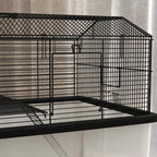 Black wire cage side with platform and front door on the upper tier