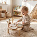 Toddler playing wooden drum and xylophone toy with three drums and two mallets
