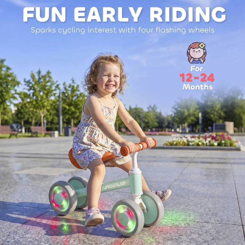 Orange-seat toddler balance bike with glowing LED wheels and green frame, adjustable seat