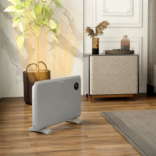 Grey electric convector heater standing on floor with front control panel