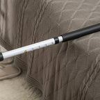 Close-up of white grab bar with black grip section and height adjustment holes