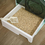Light blue and white hooded cat litter tray filled with beige pellets and scoop
