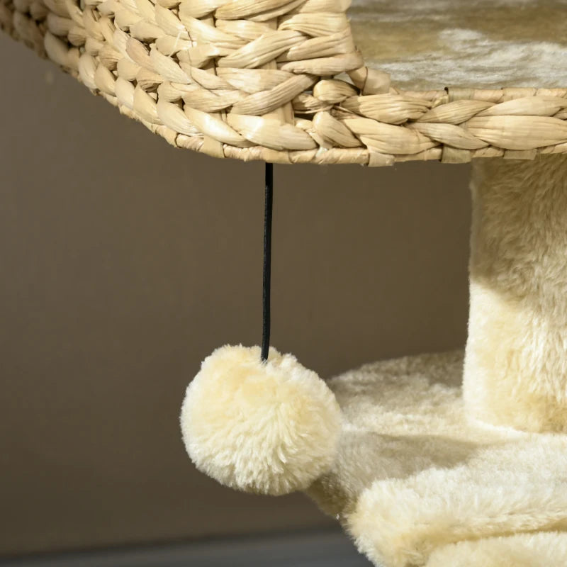 Hanging pom-pom toy ball on beige cat tree platform and scratching post