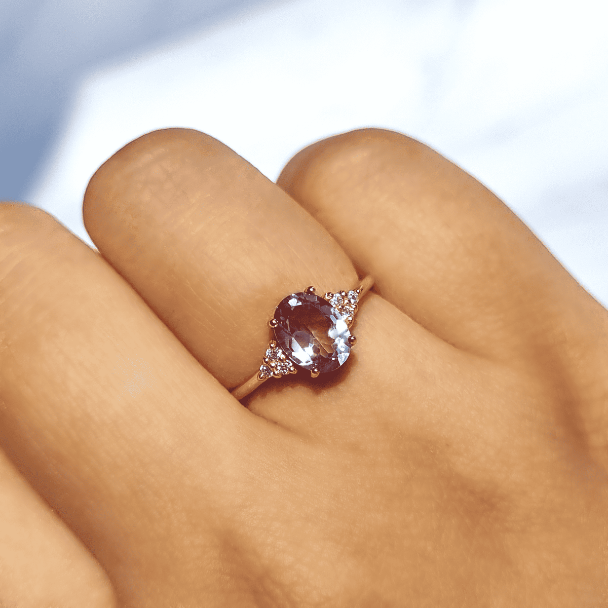 Rose gold vermeil amethyst ring on finger with small pave-style accents