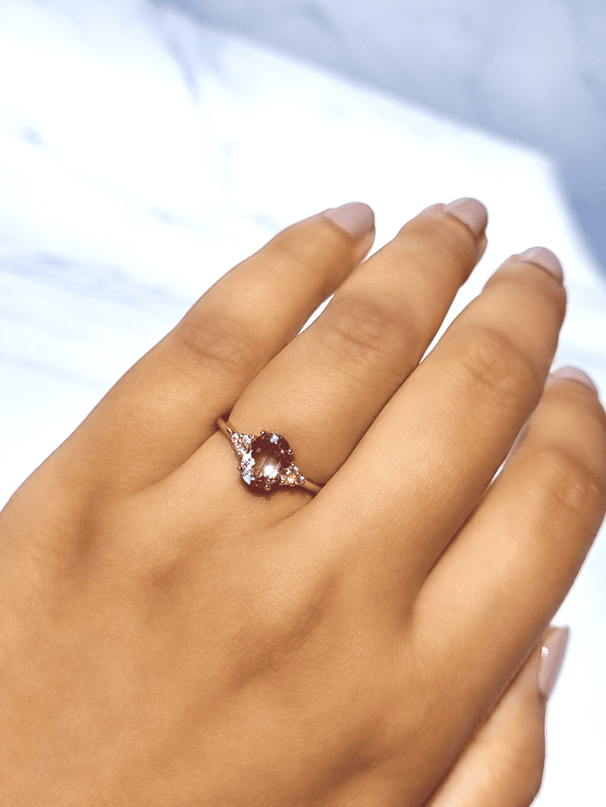 Rose gold vermeil amethyst ring worn on hand with oval center stone