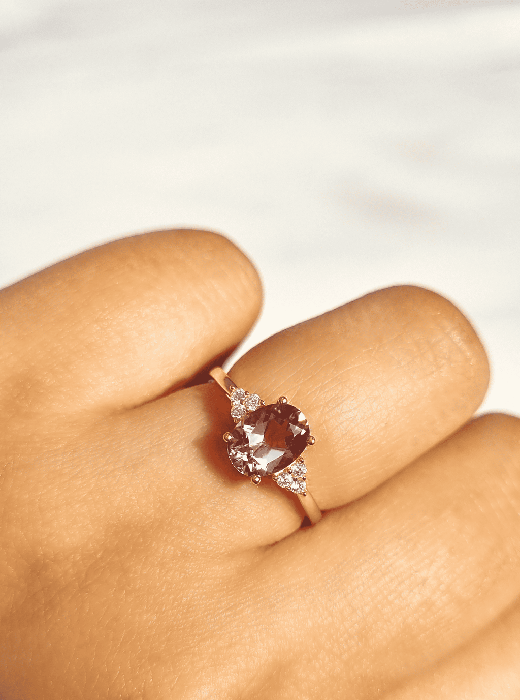 Amethyst ring on finger with oval lavender center and tiny sparkle accents