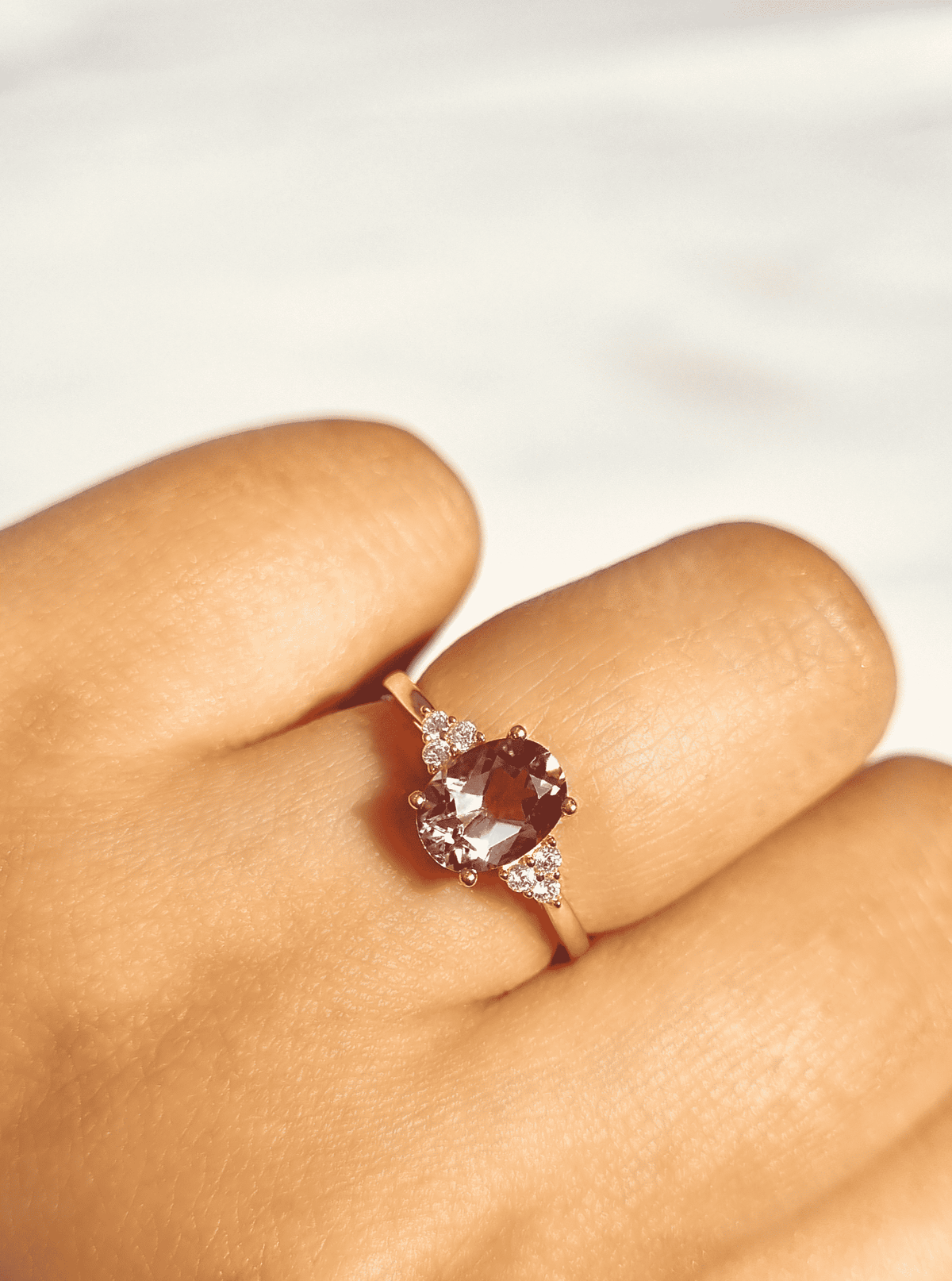 Amethyst ring on finger with oval lavender center and tiny sparkle accents