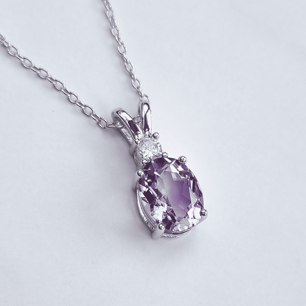 Sterling silver pendant necklace with oval faceted lavender amethyst and halo stones