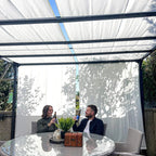 Cream-white pergola with retractable canopy and side curtains over outdoor seating