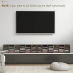 Dark wood-effect CD storage unit on the floor beneath a wall-mounted screen.
