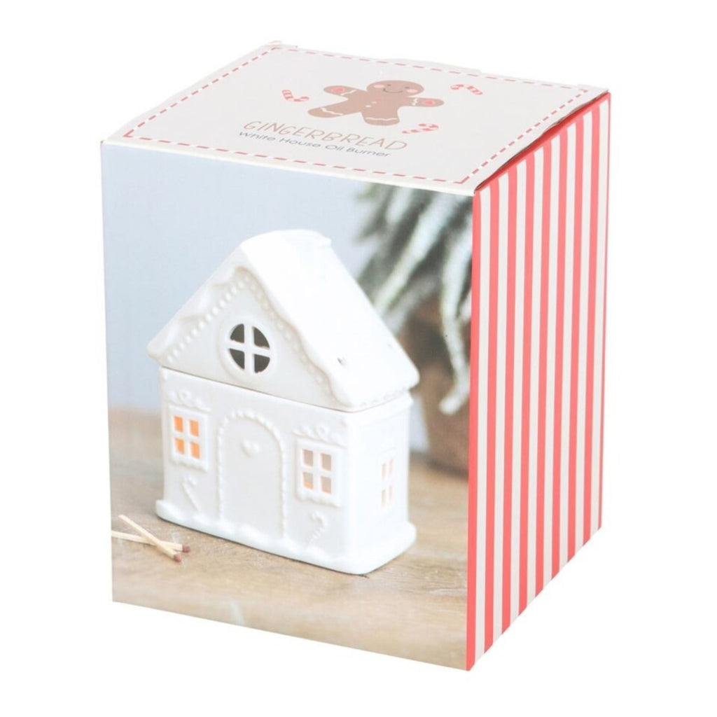 White house-shaped candle in a decorative box with gingerbread design