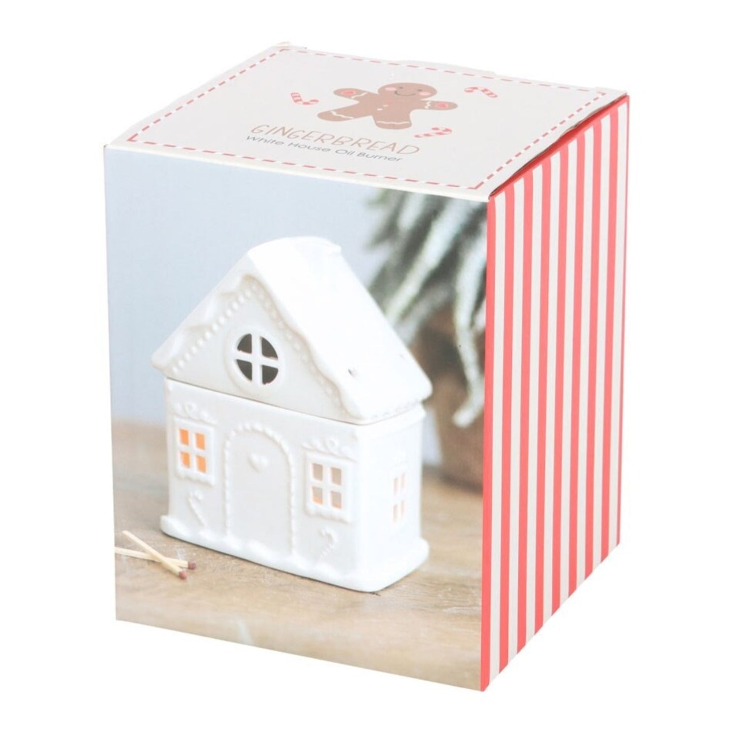 White house-shaped candle in a decorative box with gingerbread design
