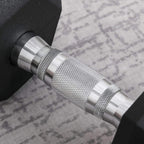 Knurled silver handle of black rubber hex dumbbell with textured grip details