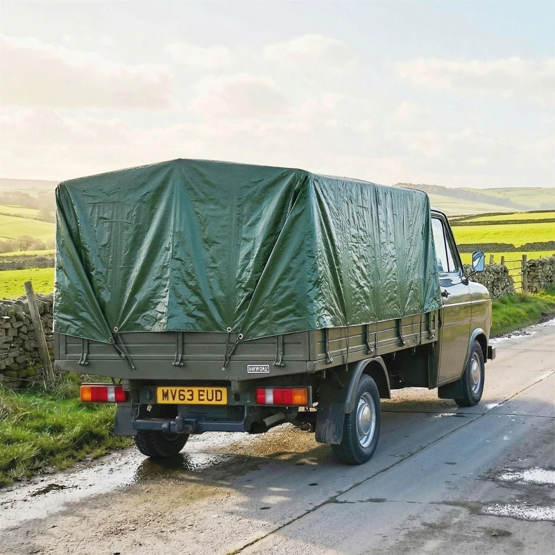 Green waterproof tarpaulin cover for a pickup truck bed, secured with grommets