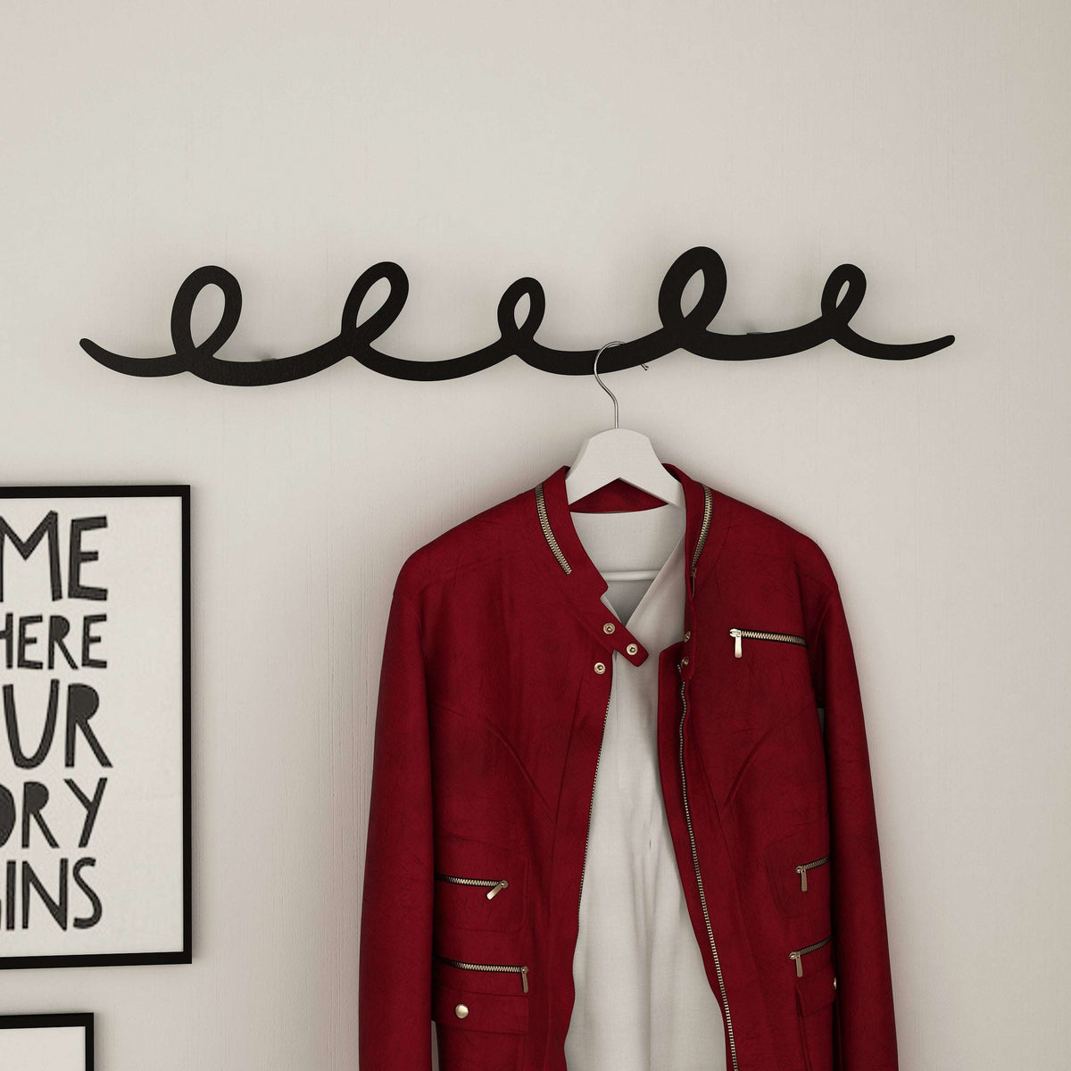 Metal script hanger with curved hook, holding a red jacket