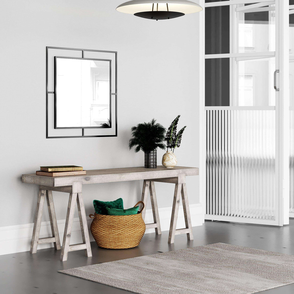 Square wall mirror with dark frame and reflective center above a console table.