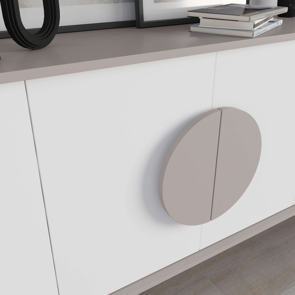 Close-up of white cabinet door with large taupe round handle and vertical seam